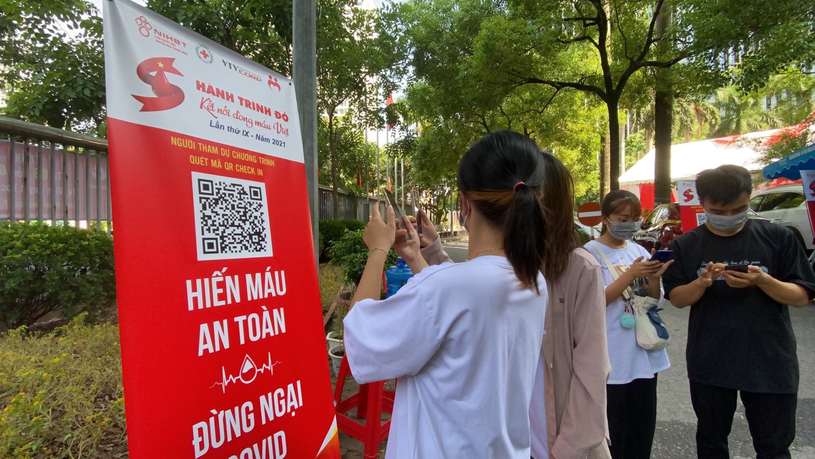 Những bạn trẻ đến hiến máu được hướng dẫn thực hiện quét mã QR Code để phòng dịch Covid - 19.