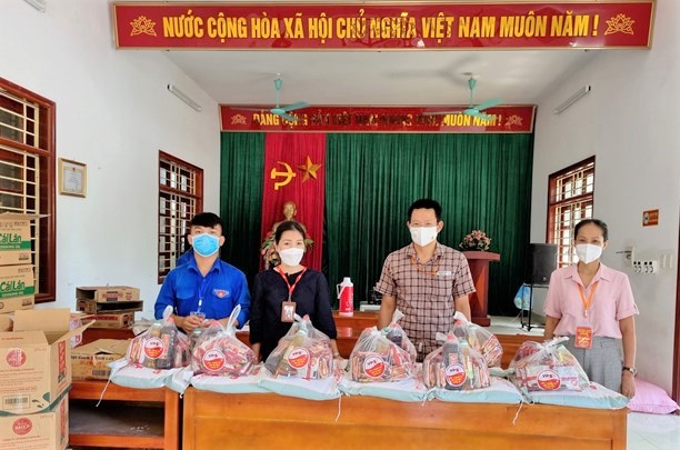 Chủ tịch UBND xã Đặng Ngọc Quyền tiếp nhận những suất quà là nhu yếu phẩm của doanh nghiệp trên địa bàn xã để trao cho những hoàn cảnh khó khăn và khu dân cư ở trọ. 