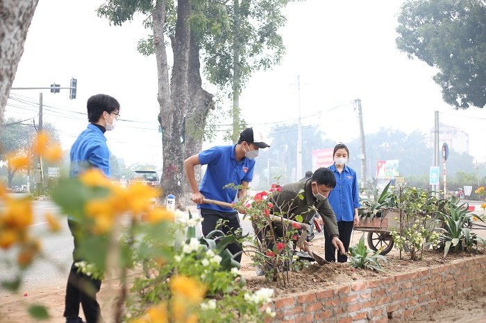Thanh niên chung tay trồng hoa làm đẹp cảnh hồ tại xã Tiền Phong.