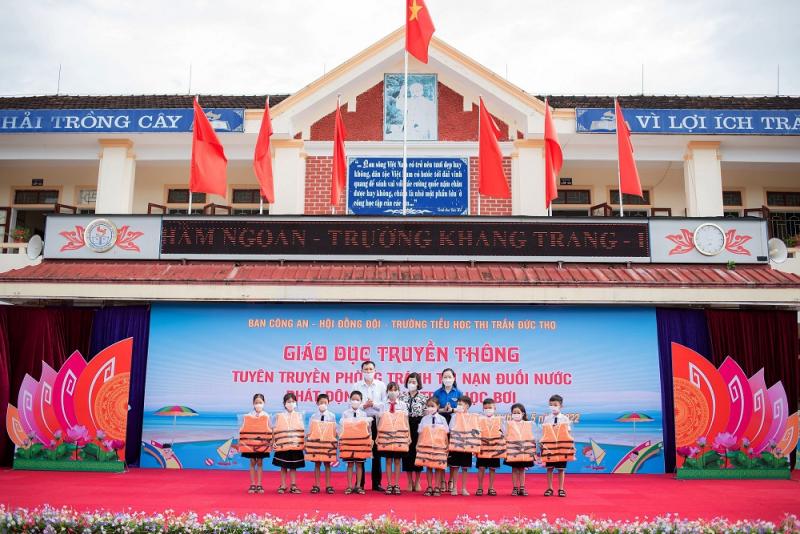 Phát áo phao cho các học sinh đăng kí học bơi