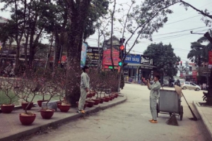 Hạnh phúc giản đơn ngày cận Tết: 2 cô lao công tạo dáng bên hoa đào, chụp ảnh cho nhau sau khi quét dọn đường phố sạch sẽ